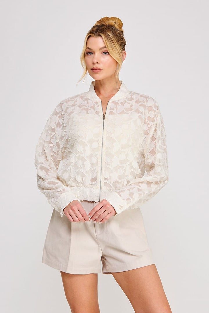 Allie Rose Lea semi-sheer off-white blouse jacket displayed on a hanger, showcasing lightweight, stylish jacket with semi-transparent fabric.