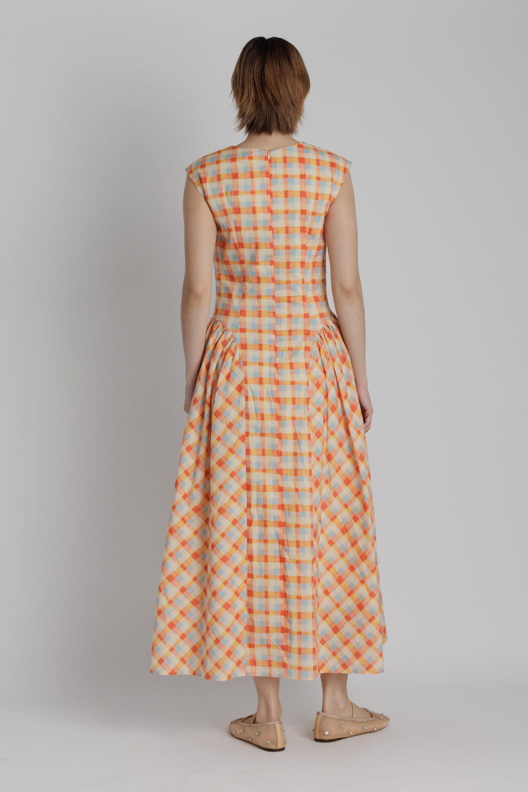 Aureum Mila plaid midi dress with long sleeves and a fitted waist, featuring a classic checkered pattern in shades of red and black.