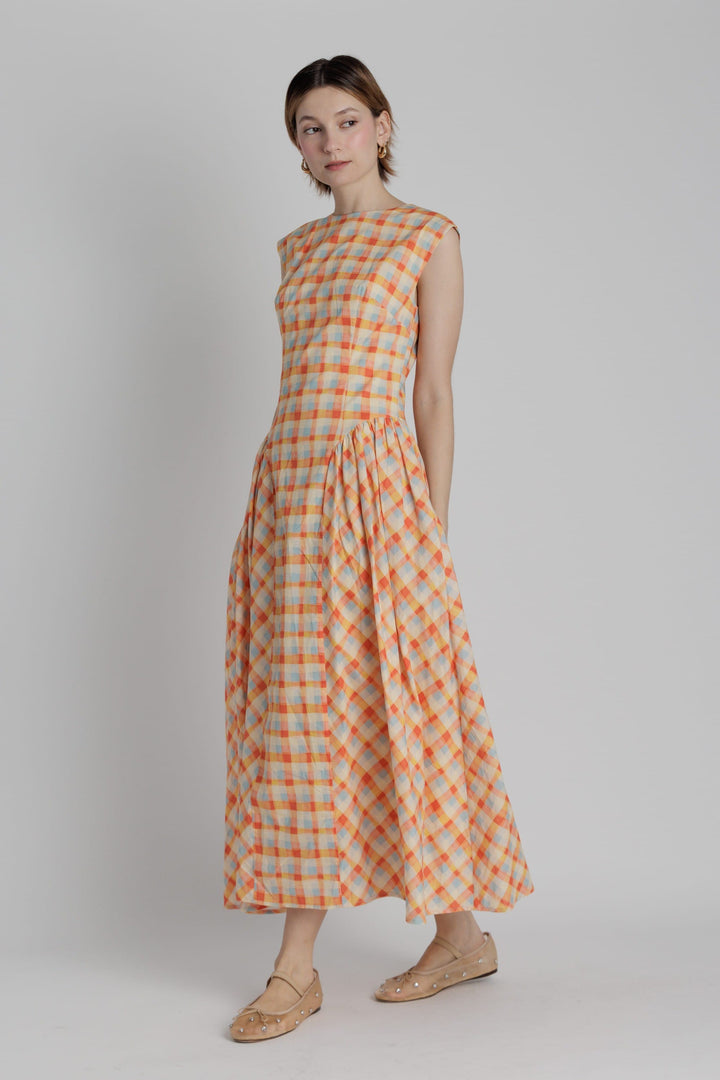 Aureum Mila plaid midi dress featuring a fitted bodice, long sleeves, and a flowing skirt in a classic plaid pattern.