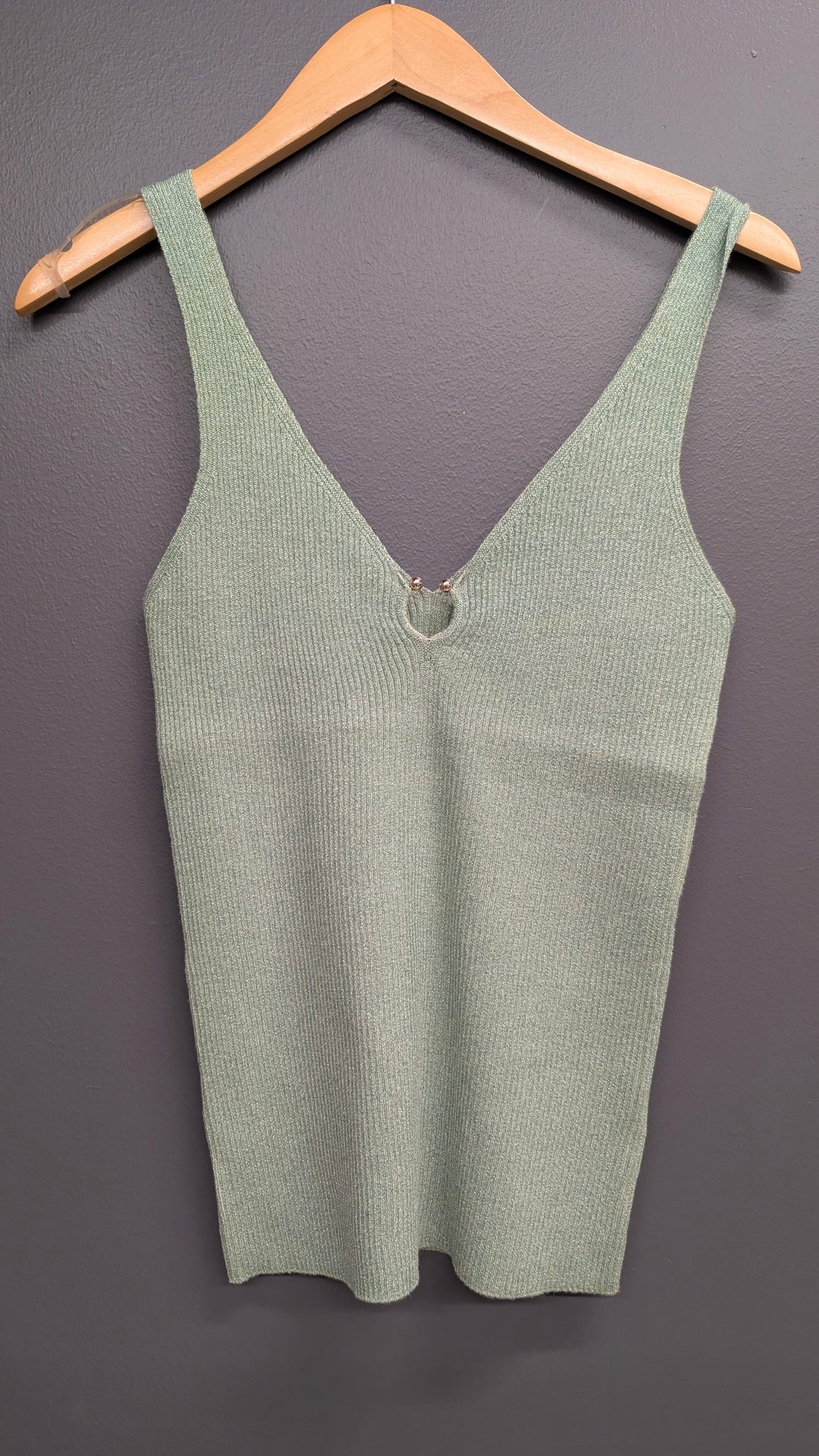 Soft green Esqualo Lyla Shimmer Tank top displayed on a hanger, showcasing its lightweight fabric and subtle shimmer details.