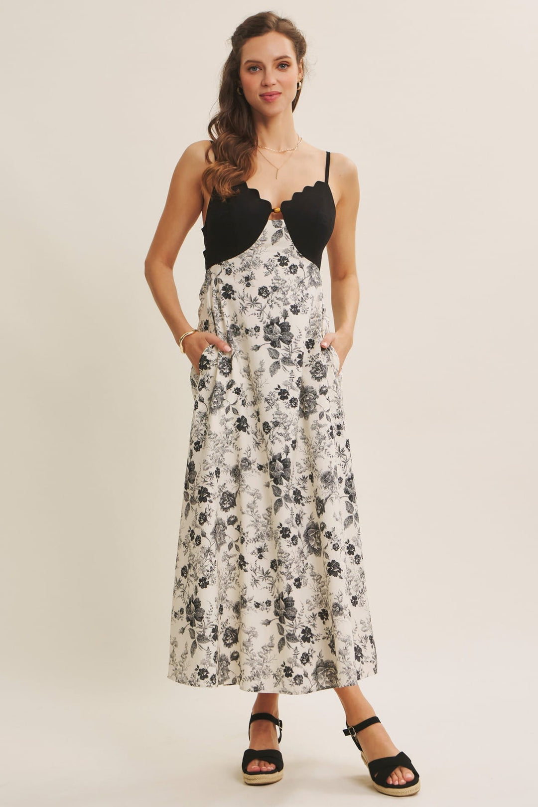 Black In February midi dress featuring eye-catching scallop cutouts and contrasting details, perfect for stylish occasions.