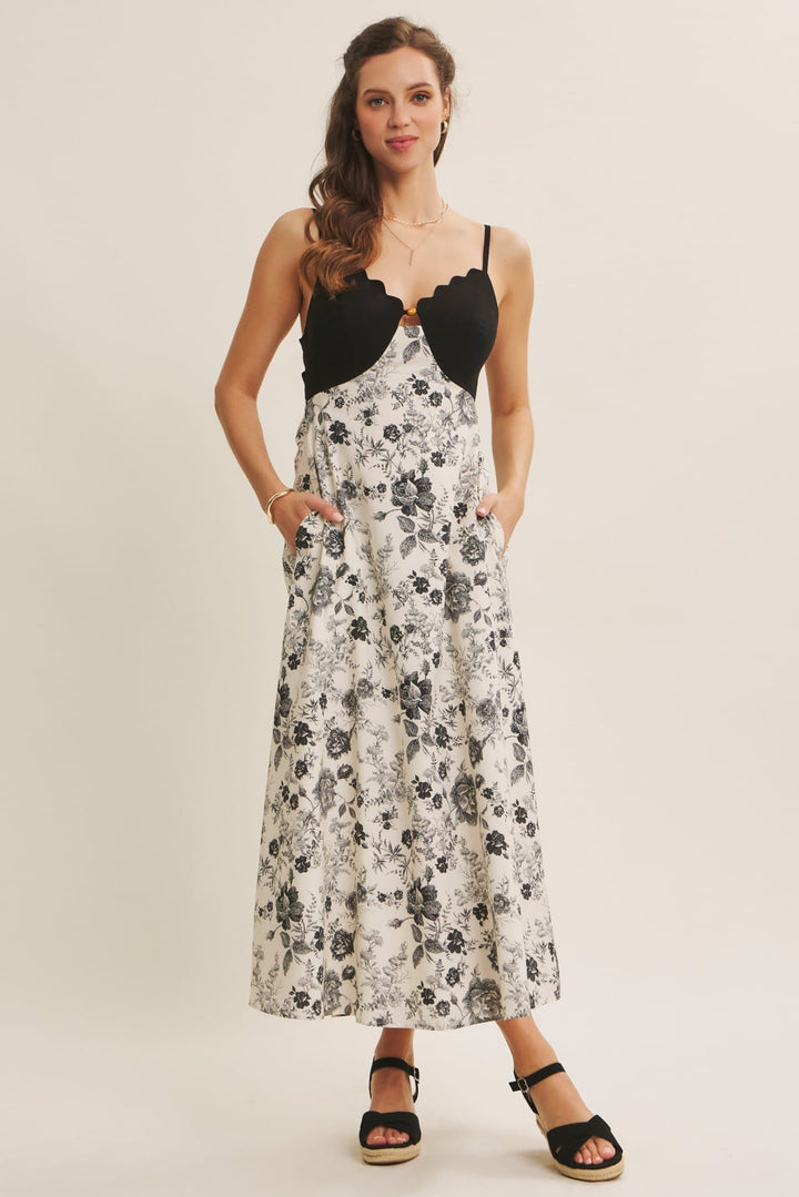 Black In February midi dress featuring eye-catching scallop cutouts and contrasting details, perfect for stylish occasions.
