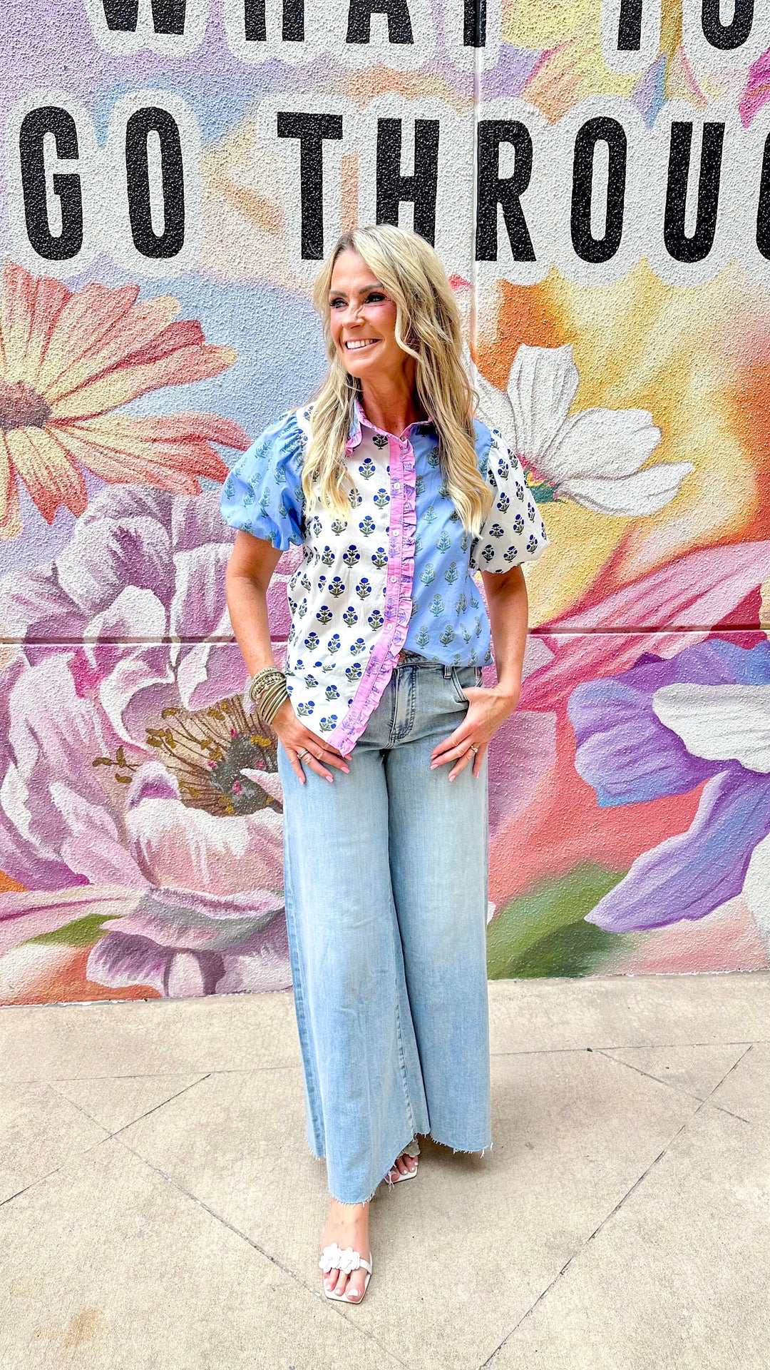 J.NNA Cora Floral Colorblock Top, stylish women's top with vibrant floral and colorblock design, displayed on a hanger.