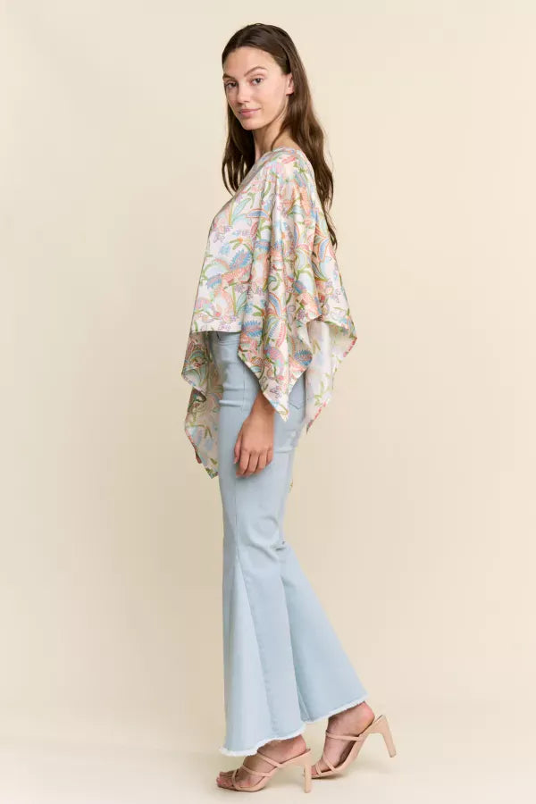 J.NNA Sunset Palm Drape Top featuring a flowy fabric with sunset and palm leaf print, styled on a model.
