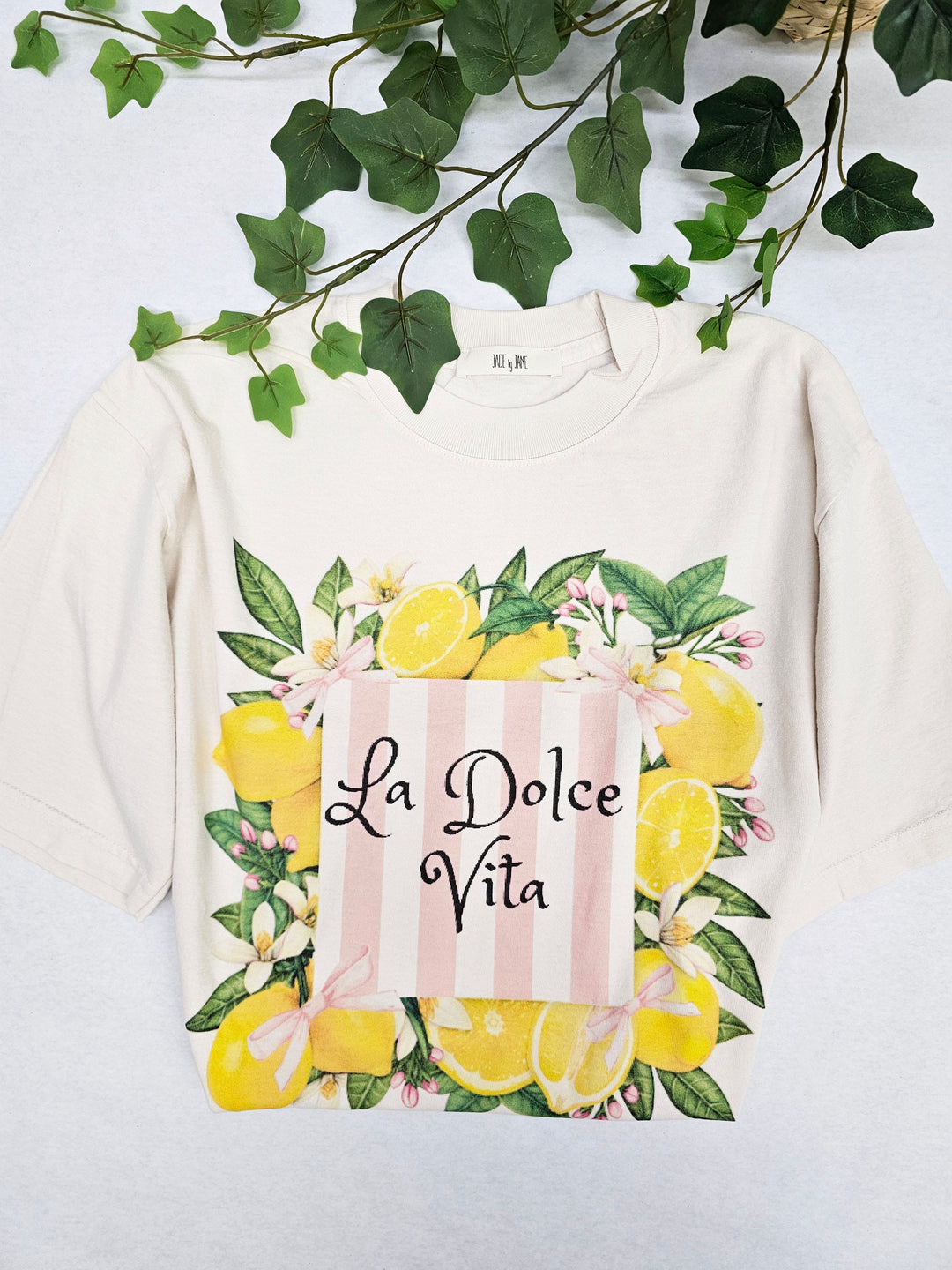 Cream-colored Jade by Jane La Dolce Vita Lemon Graphic Tee with vibrant lemon print on front.