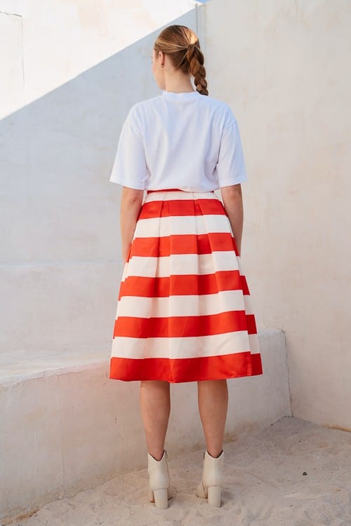 Jade by Jane Piper Pleated Midi Skirt in flowy fabric with pleats, styled with a casual top on a model.