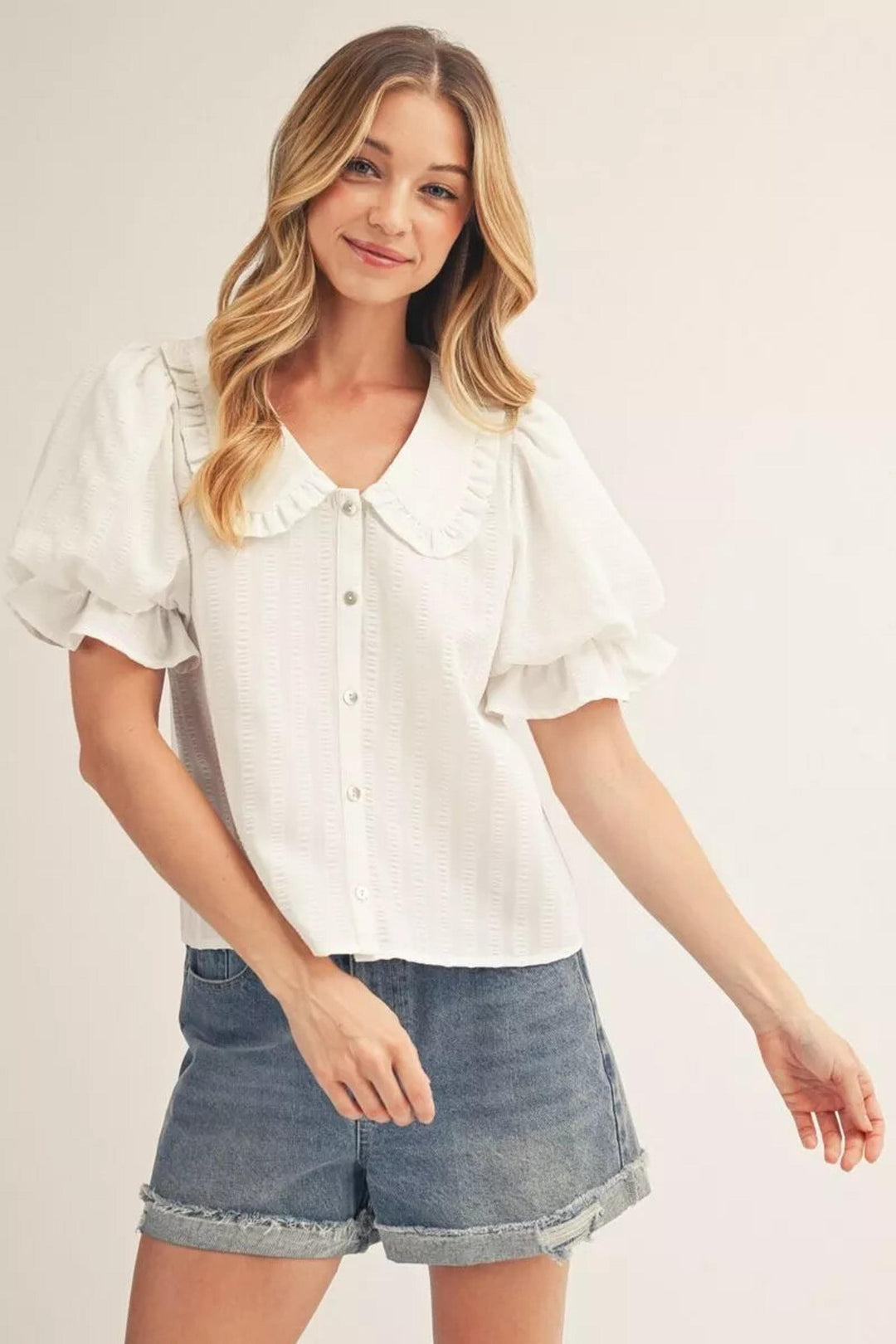 White Gabriela Puff Sleeve Top by Jodifl, featuring fitted bodice and puffed sleeves, shown on a model.