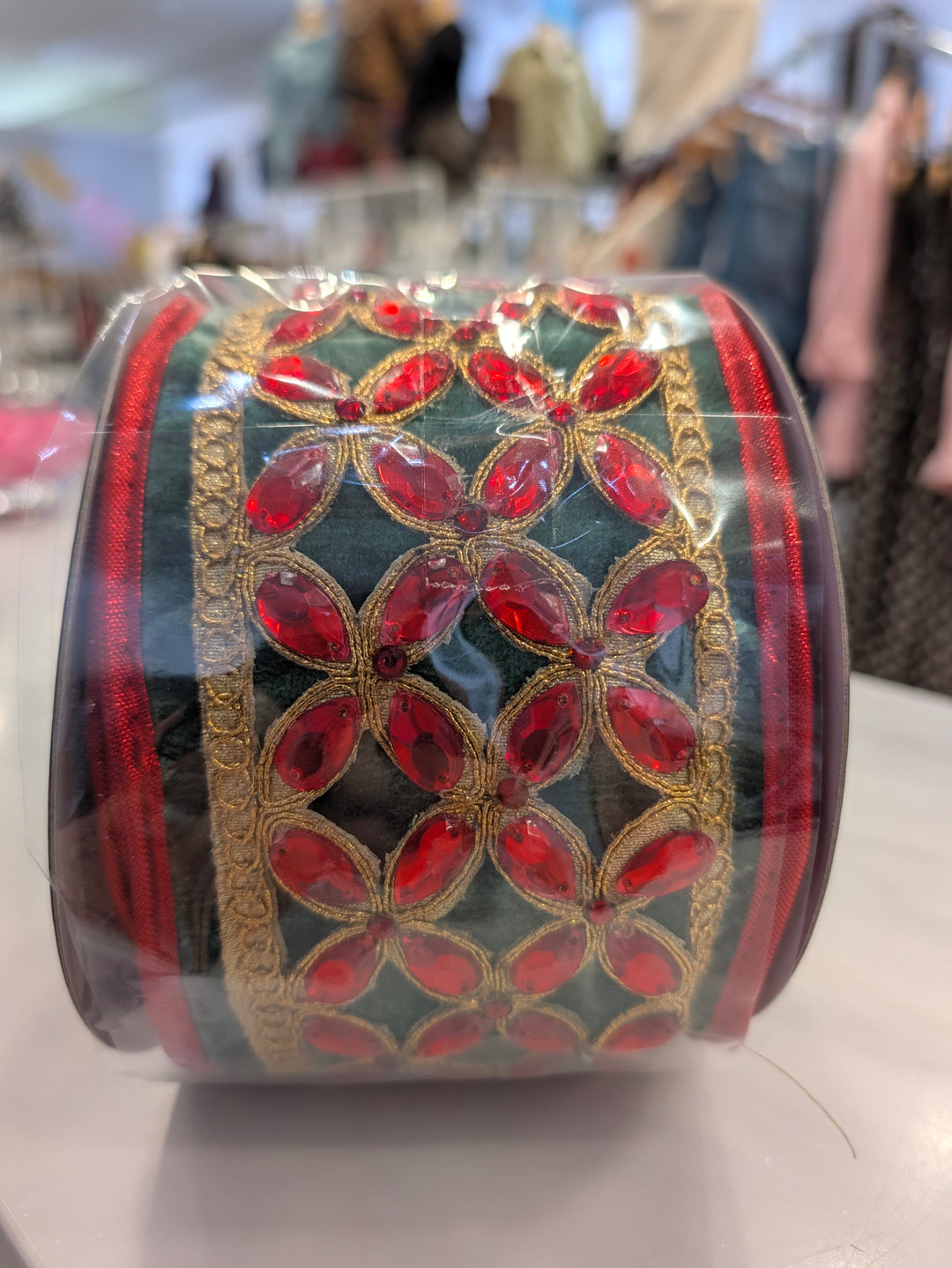 Green velvet decorative ribbon with red floral center by John Mark Enterprises, ideal for festive decor and craft projects.