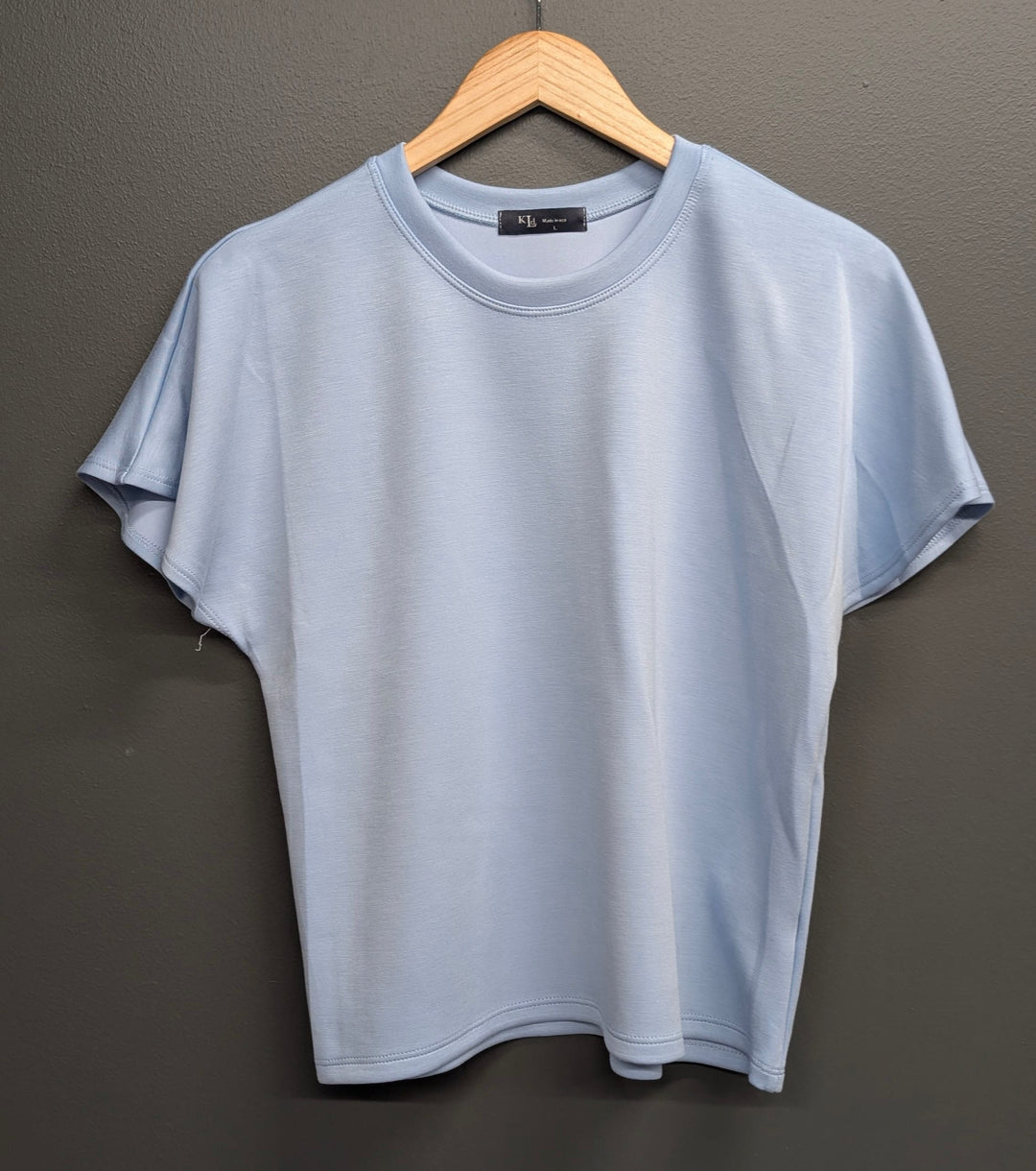 Blue Alessia Flared Top by KLd. Signature, featuring a fitted bodice and flared hem, styled on a mannequin.