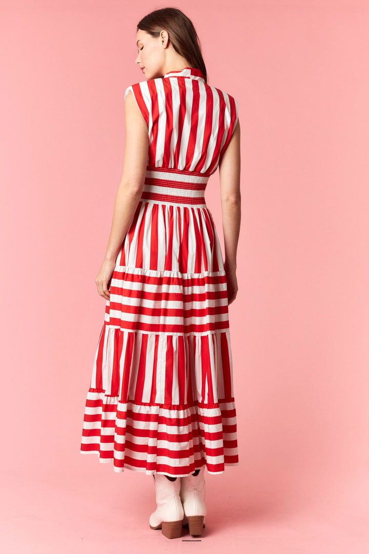 Peach Love California Eliza striped maxi dress displayed on a hanger, showcasing its flowy fabric and vibrant striped pattern.