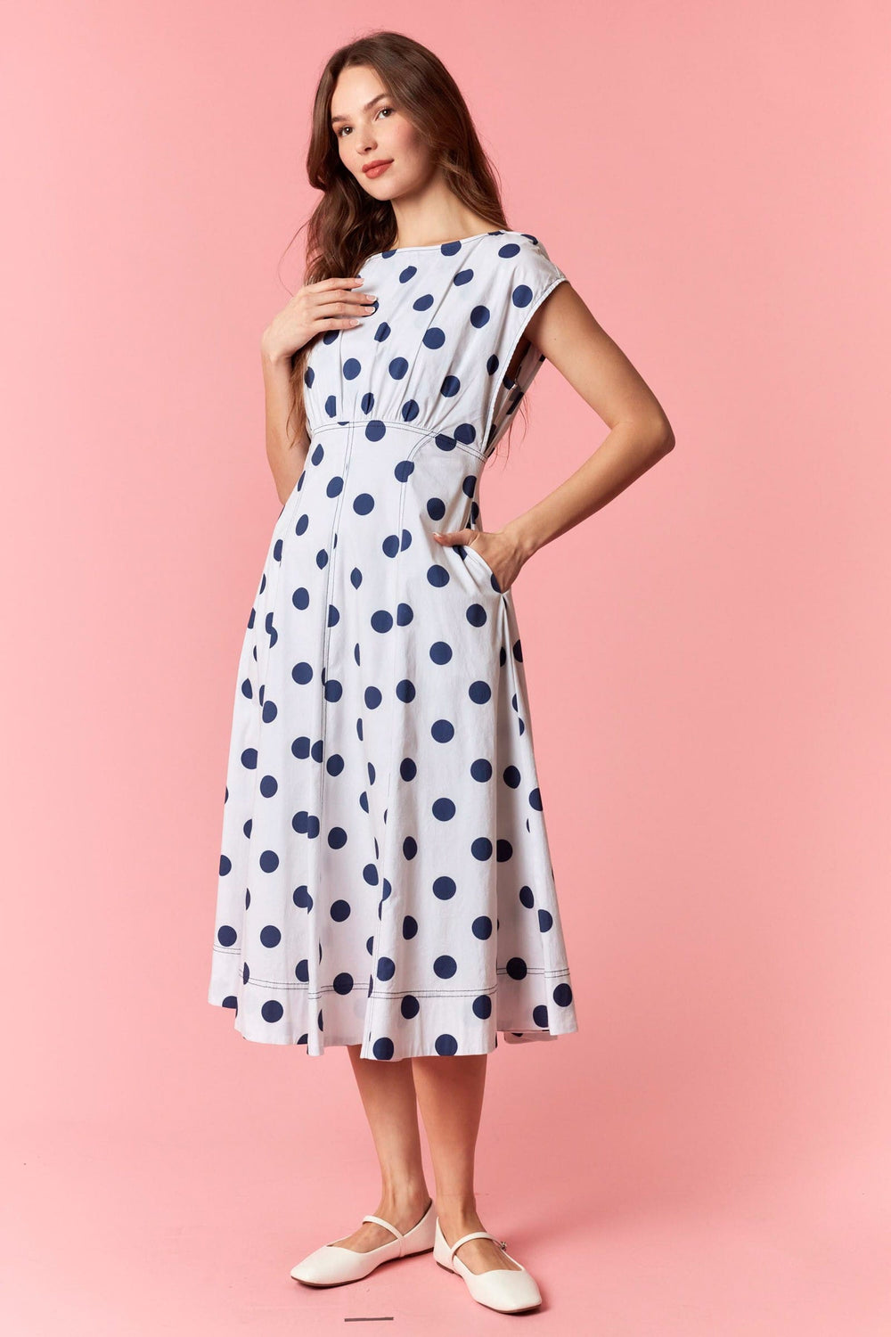 Peach Love California Harper polka dot midi dress displayed on a hanger, featuring a flowy design and classic black and white polka dots.