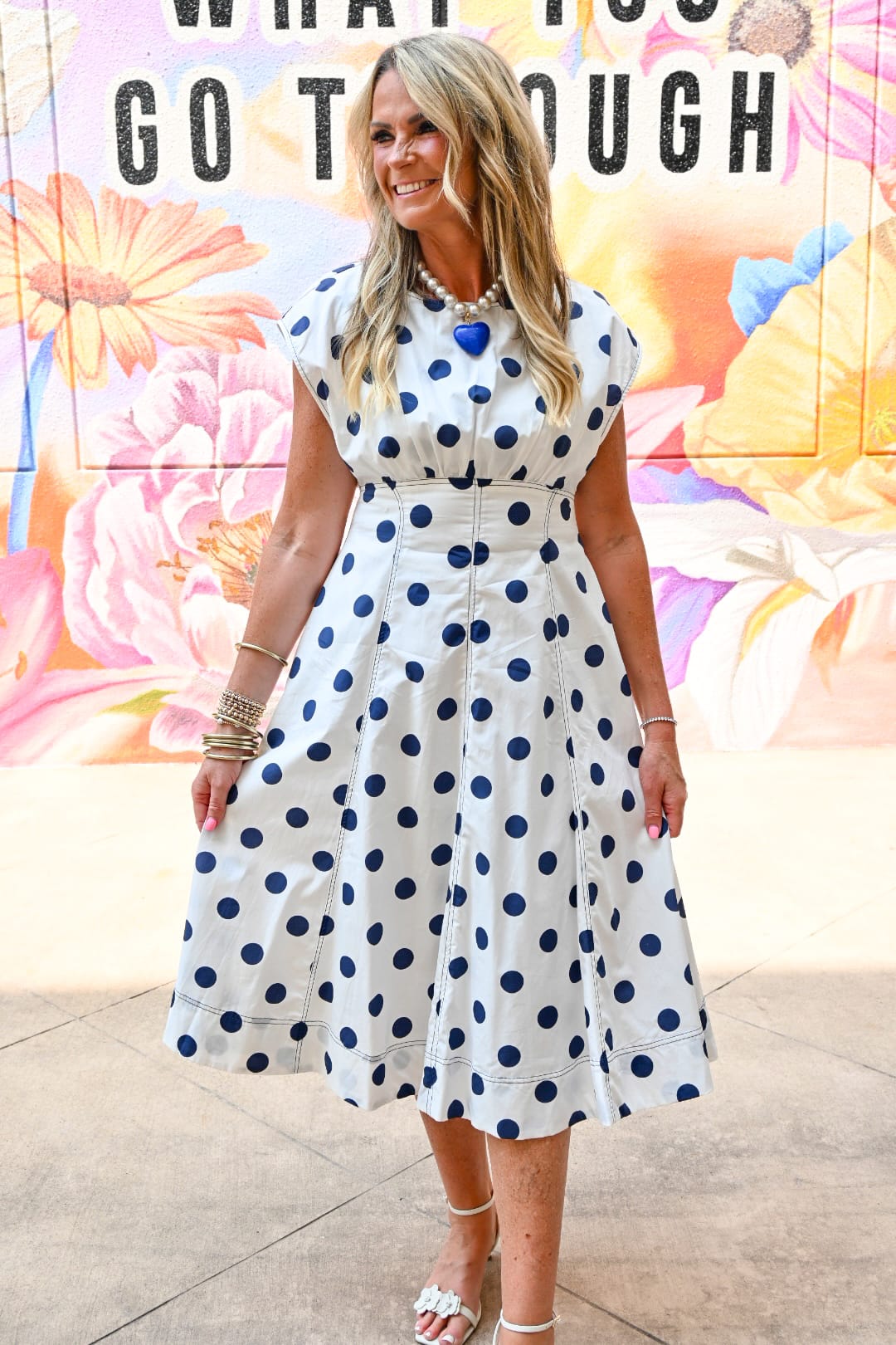 Peach Love California Harper polka dot midi dress displayed on a model, featuring a flowy fabric and classic black and white polka dot pattern.