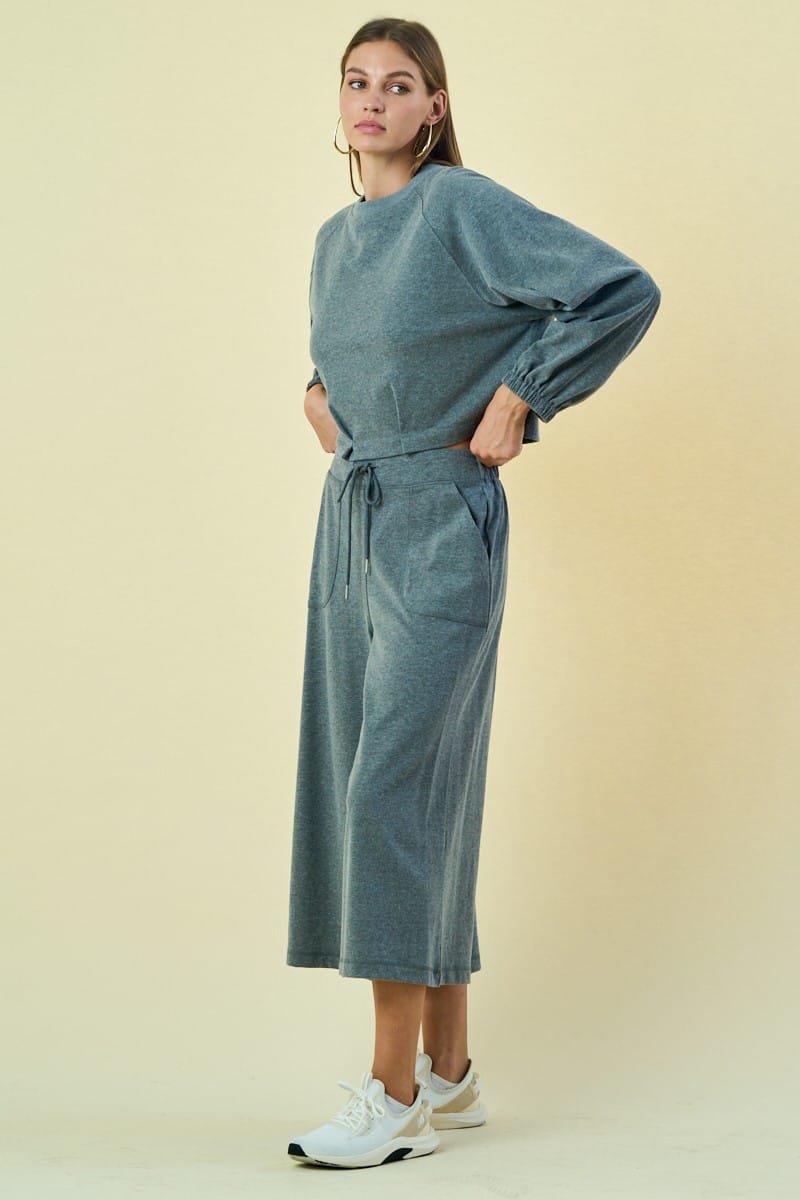 Dark heather gray Malaya buttoned sweatshirt by The Greii, featuring a relaxed fit and button details on the front.