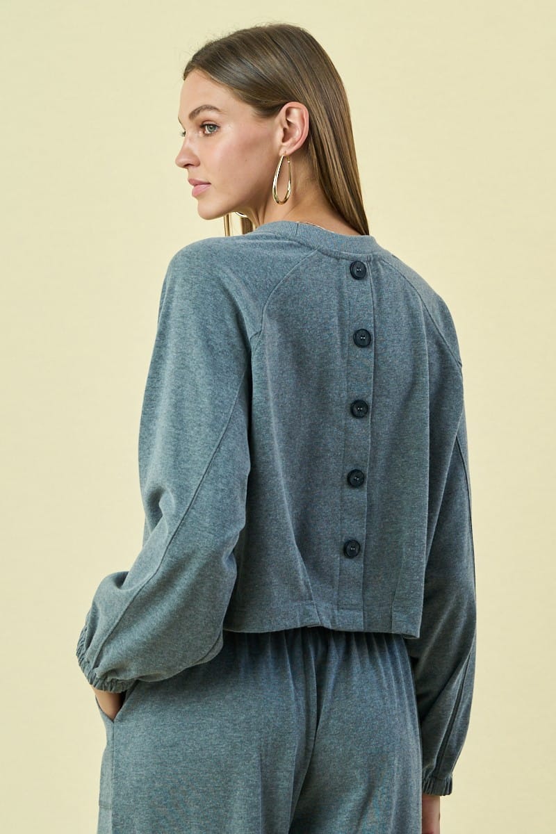 The Greii Malaya buttoned sweatshirt featuring a relaxed fit, soft fabric, and button details on the front.