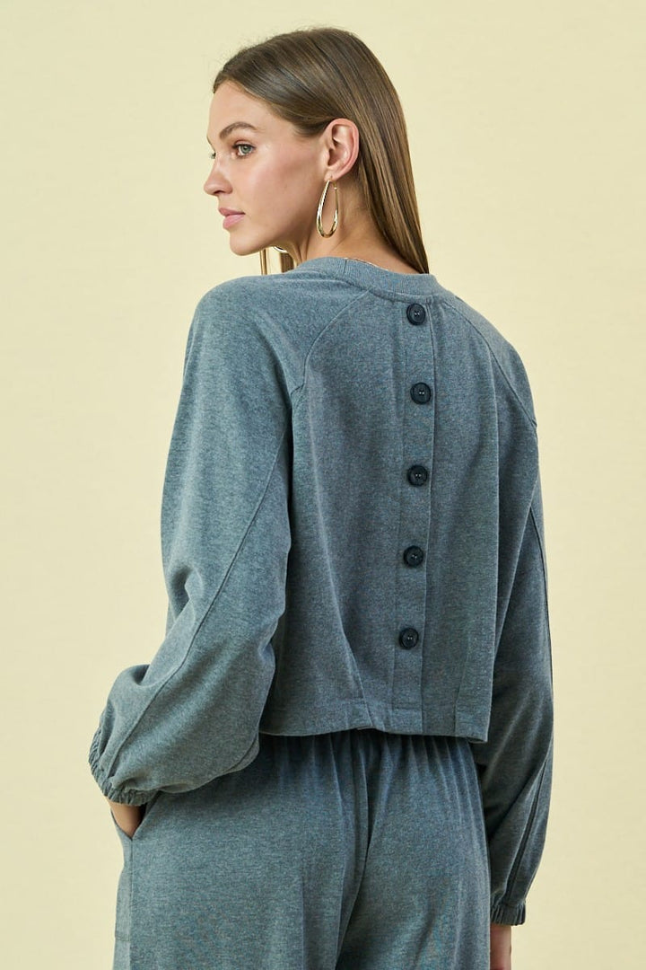 The Greii Malaya buttoned sweatshirt featuring a relaxed fit, soft fabric, and button details on the front.