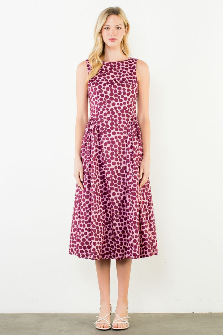 Pink Wrenley Dots Midi Dress by THML featuring a fitted bodice and flowing skirt, shown on a model.