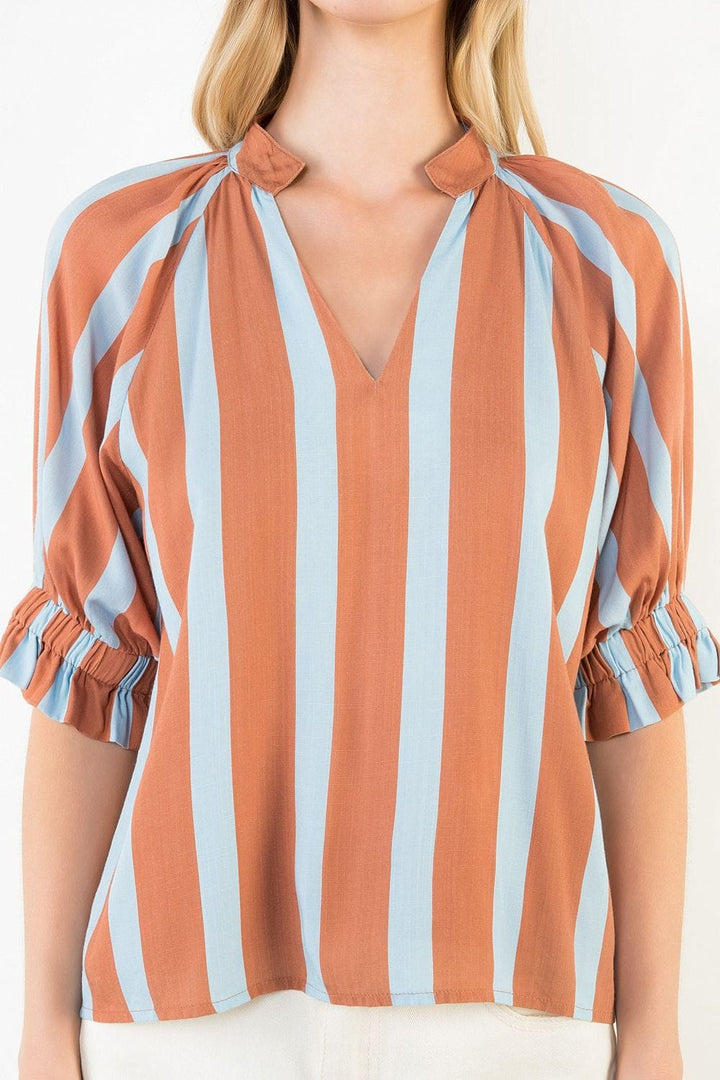 ThML Melany striped V-neck top displayed on a hanger, featuring a casual fit with bold horizontal stripes in various colors.